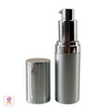 A luxury silver cosmetic pump bottle with its cap sitting on the side
