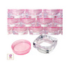 Mini square cosmetic sample jars with pink lids in stacks and in the front is a clear square jar base up side down also a clear jar cap next to it